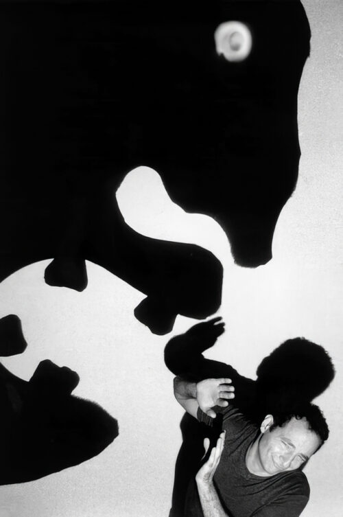 Paul Zaloom cowering beneath a huge dentist shadow thrown across the wall by an overhead projector