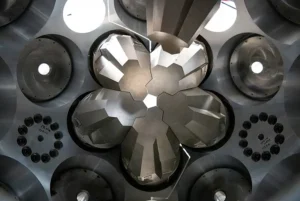 A close-up view inside a particle detector showing complex, geometrically arranged metallic components reflecting light, likely part of the GRETA array at FRIB.