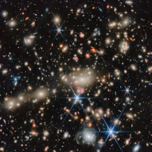 A glowing collection of incredibly bright stars with long diffraction spikes masking smaller faint objects.